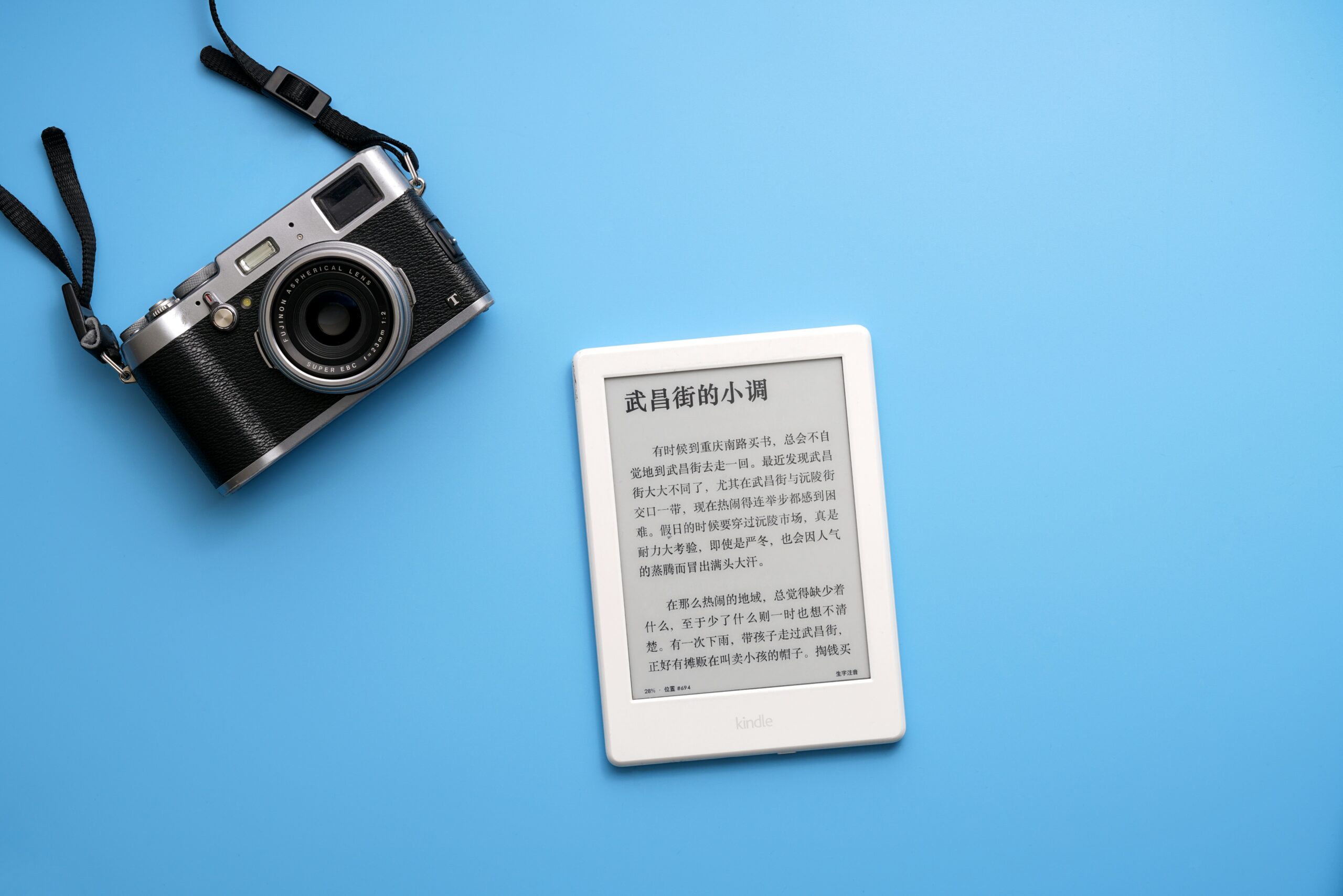 black SLR camera on and white e-book reader